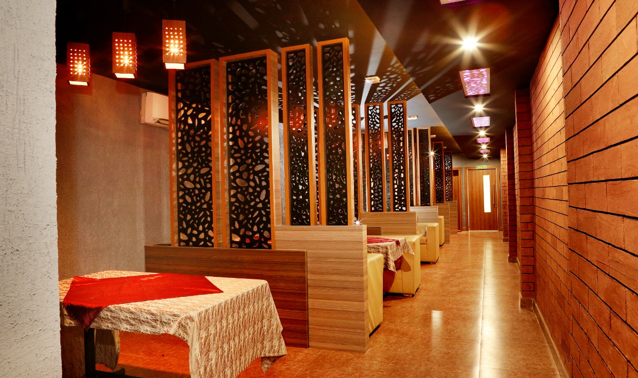 Atmospheric booth dining with carved wooden panels and exposed brick